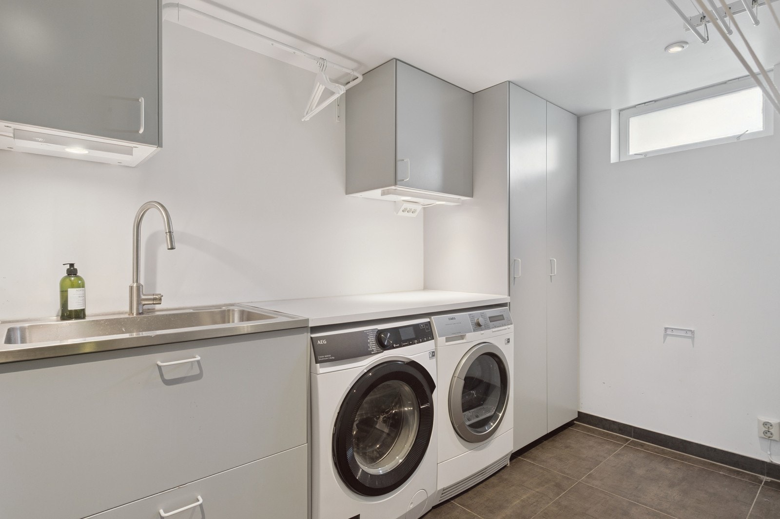 Vaskerom i kjeller med vaskemaskin og tørketrommel. Galleribilde