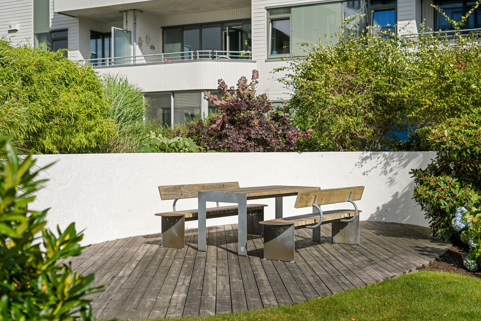 Flere fine sitteplasser på tunet hvor man kan ta lunsjen ute mens barn/barnebarna leker Galleribilde