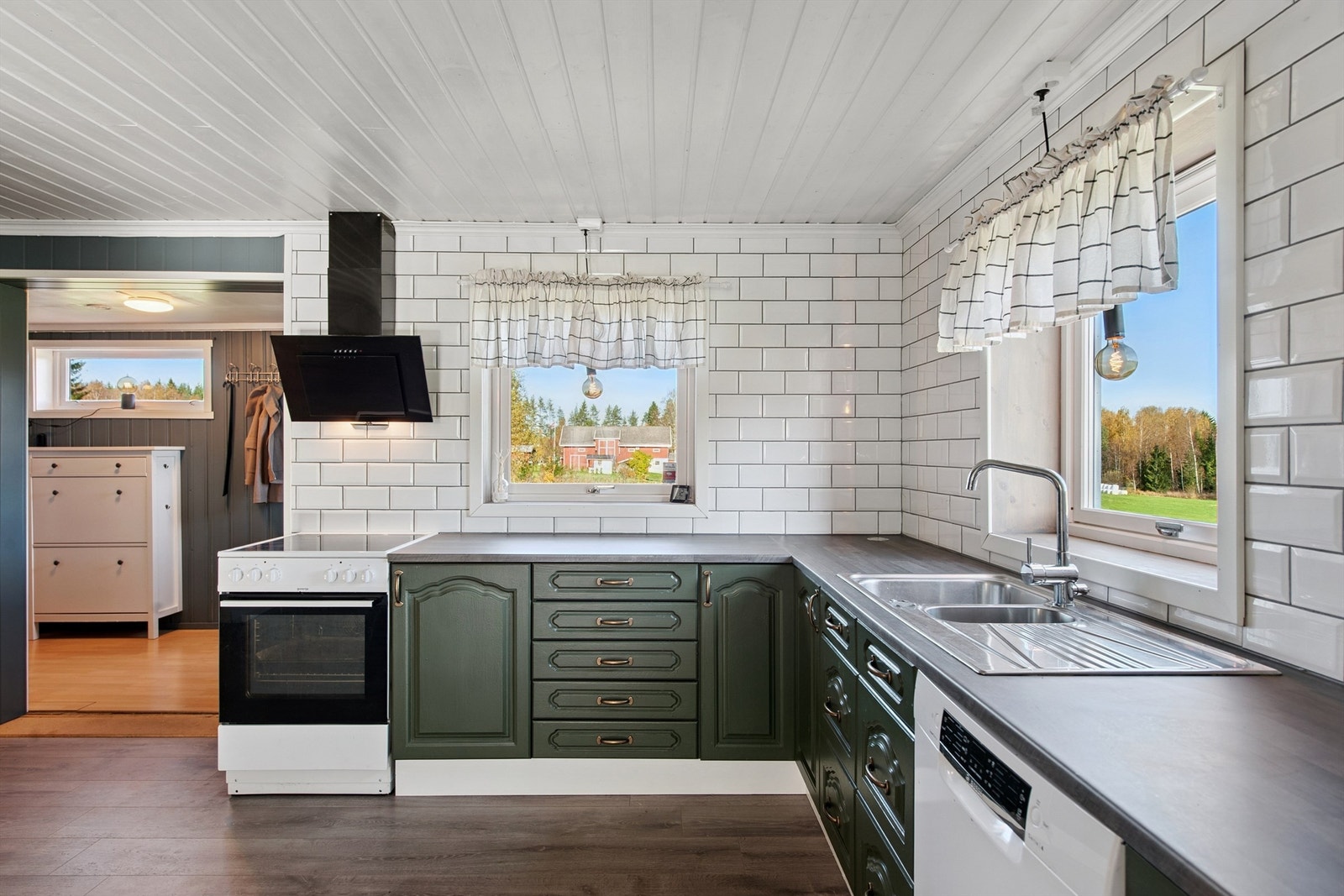 Innholdsrikt kjøkken med underskap og pene fliser fra benkeplate til himling. Galleribilde