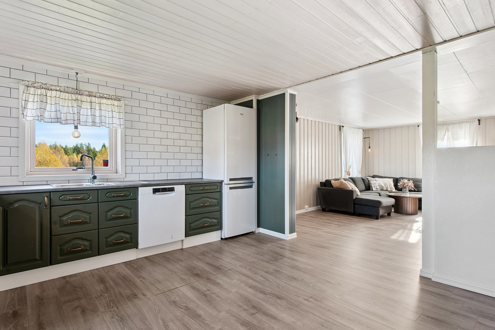 Pent, delvis åpent allrom med innholdsrik kjøkkeninnredning og stor og luftig stue, naturlig oppdelt til tv-stue og spisestue. Galleribilde