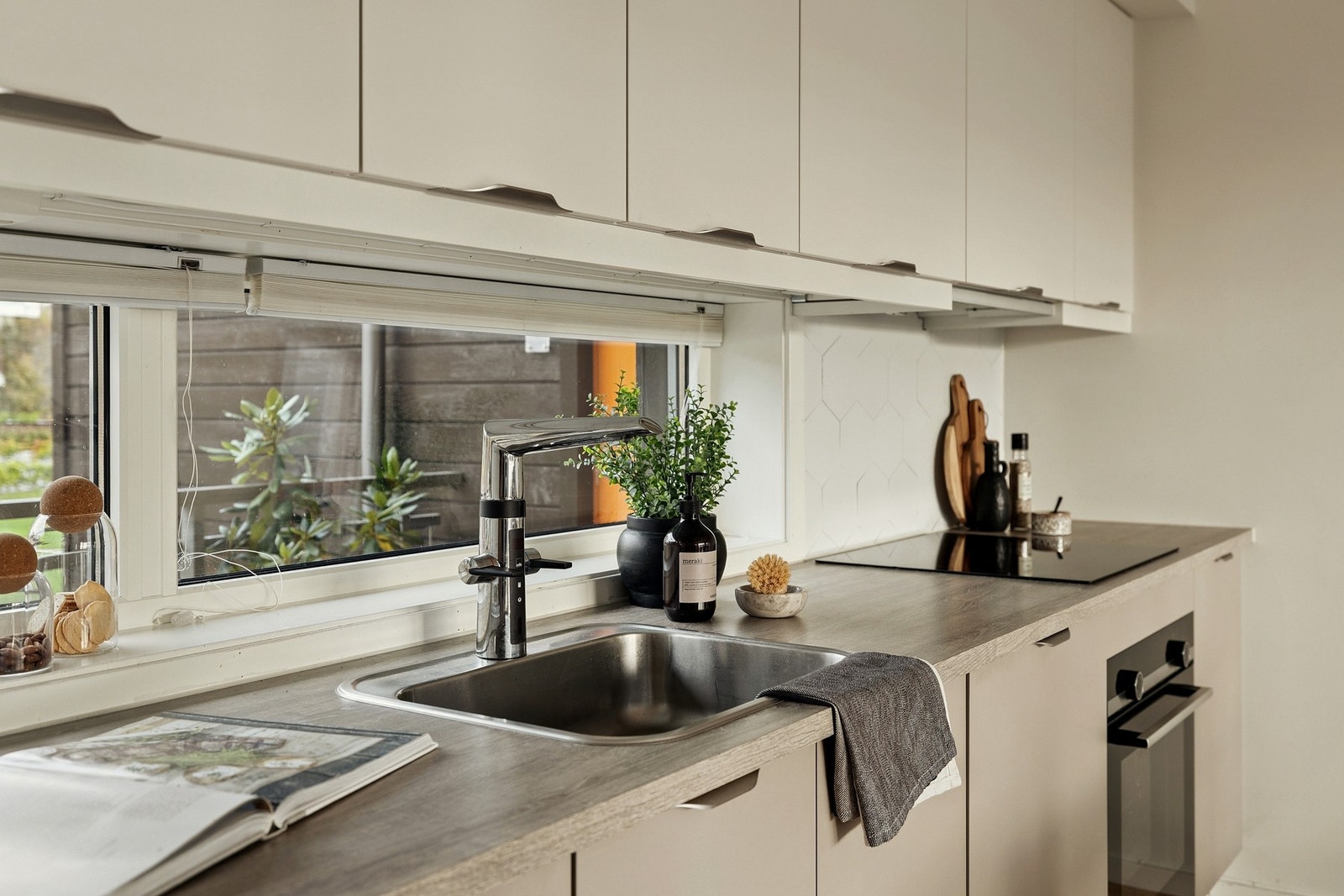 Kjøkkenet har moderne innredning med god arbeidsflate og store vinduer Galleribilde