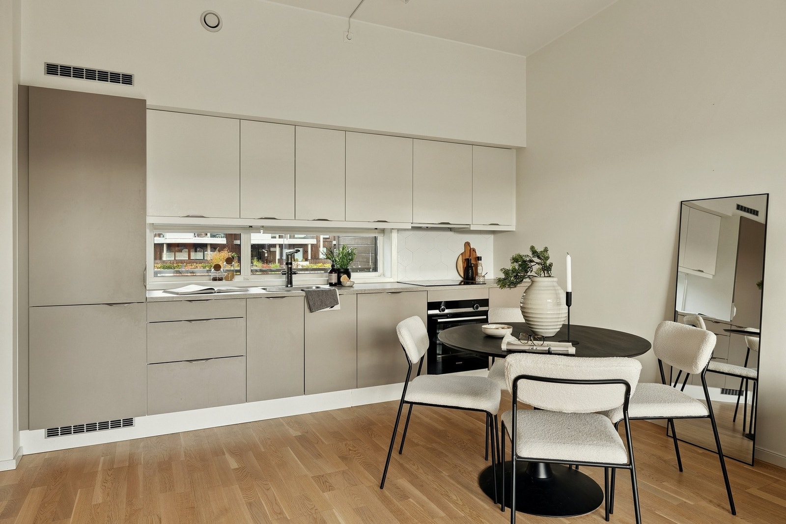 Kjøkken med slette fronter, integrerte hvitevarer og god skap- og benkeplass. Spiseplass i tilknytning til kjøkkensonen. Galleribilde