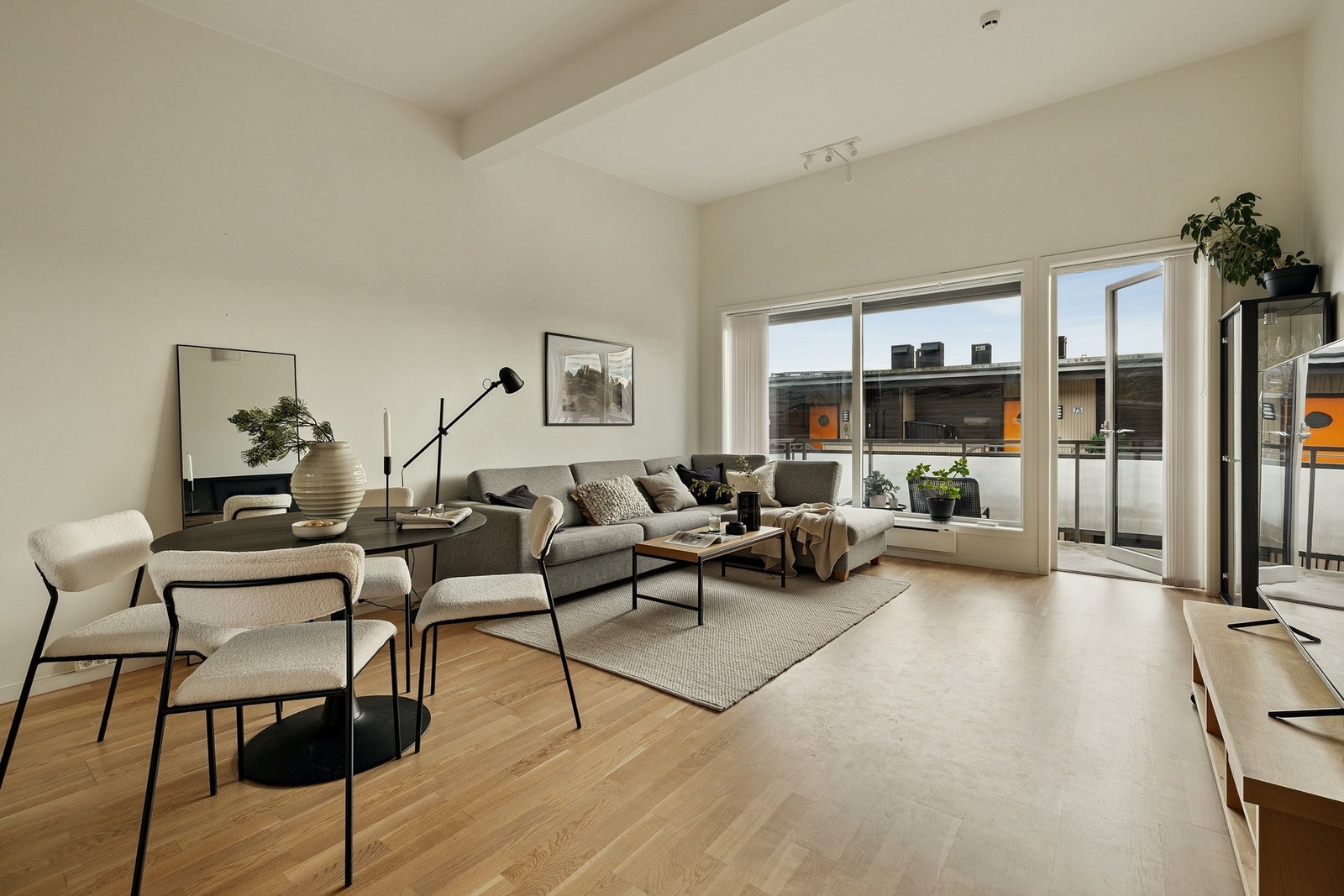 Romslig stue med åpen løsning mot kjøkken og utgang til balkong. Galleribilde