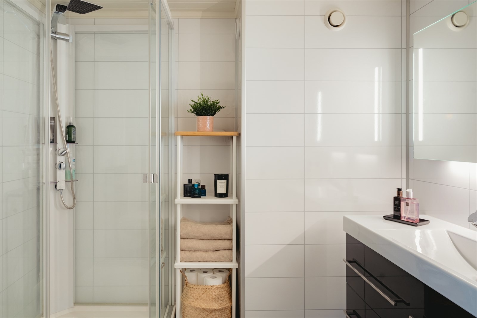 Baderommet er pusset opp i 2015. Badet har fliser på gulv, baderomsplater på vegger og malt panel med innfelte downlights i himling. Galleribilde