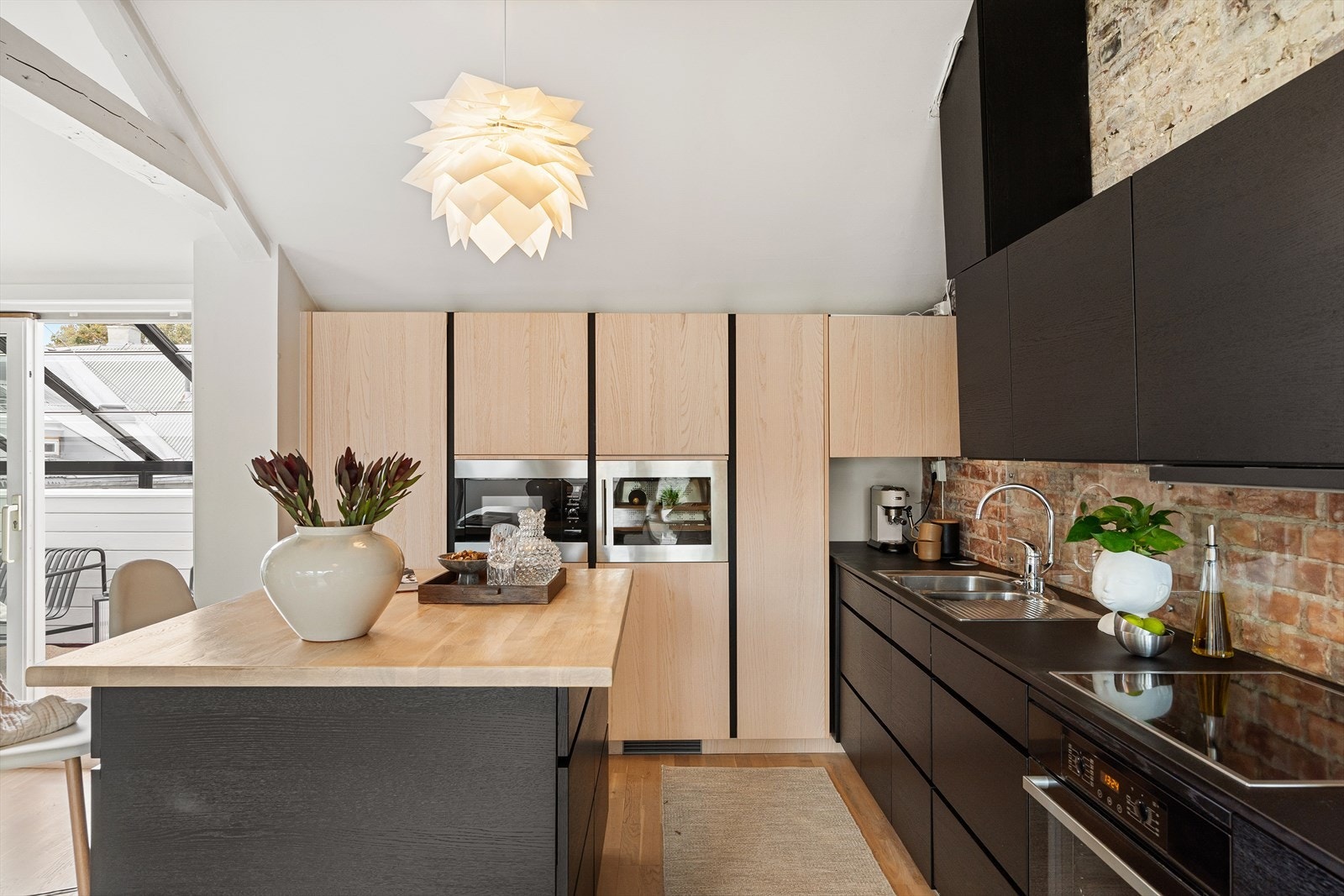 Her finnes en praktisk kjøkkenøy med laminerte fronter og heltre benkeplate, som gir både lagringsplass og sitteplass for to personer. Galleribilde