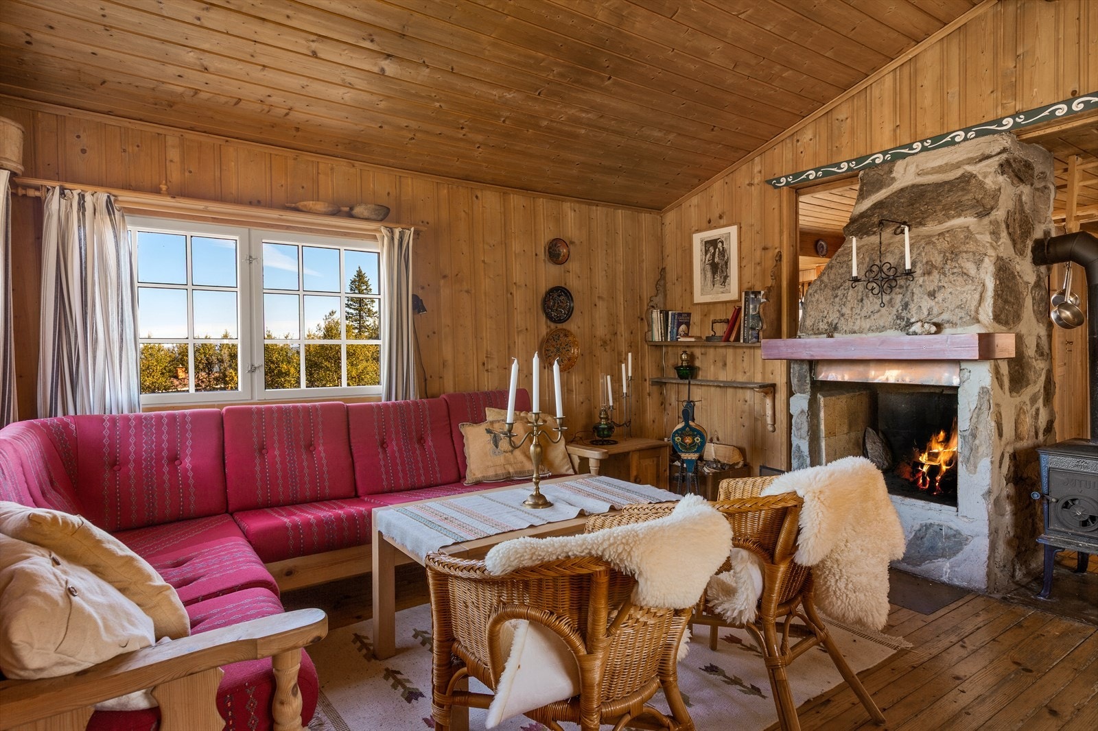 Koselig stue med panelte overflater, rausta himling og tregulv. Galleribilde