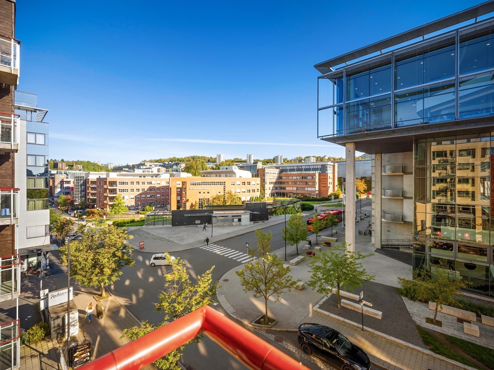 Utsyn fra leiligheten (5. etg.), åpen plass med T-bane og buss, Radisson-hotellet og BI (og frodig horisont) Galleribilde