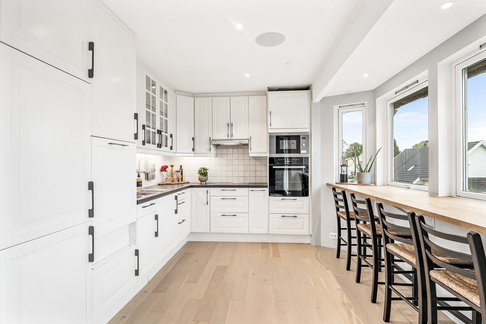 Her er det godt med skap- og benkeplass, og innredningen består av hvite profilerte fronter, laminat benkeplate og nedfelt stålvask. Galleribilde