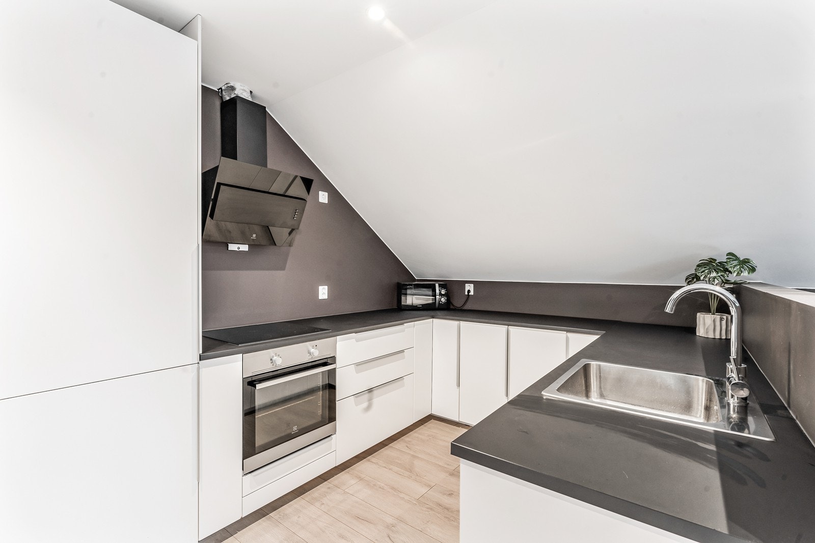 Kjøkkenet har hvit slett innredning, laminat benkeplate, integrert stekeovn, platetopp, kjøl/frys og oppvaskmaskin, samt fritthengende ventilator. Galleribilde