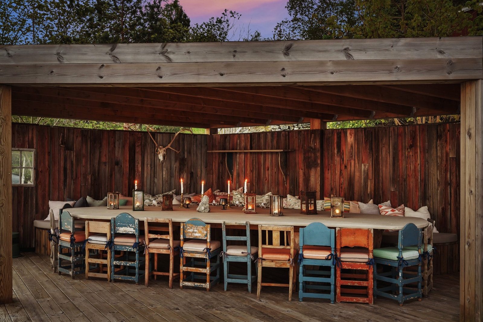 Overbygget uteplass med rustikk sjarm - perfekt for sosiale sammenkomster ved sjøen, med plass til langbord og stemningsfull belysning. Galleribilde