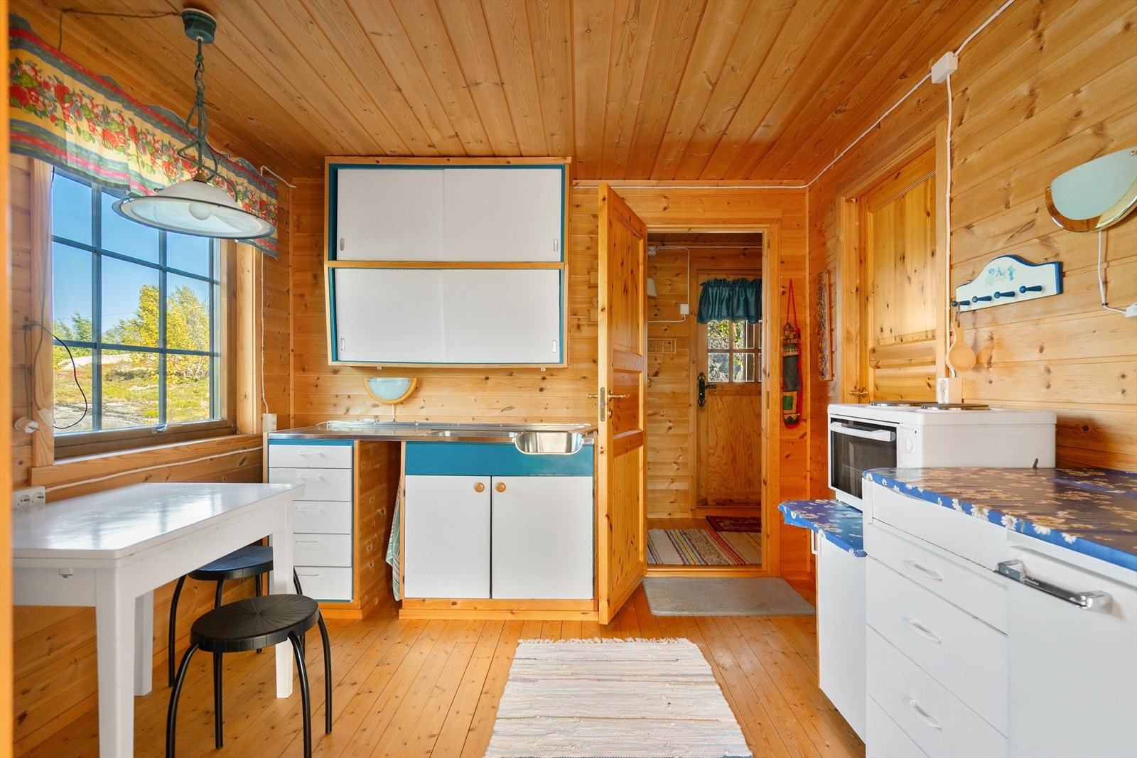 Praktisk kjøkken med god skapplass og vindu som slipper naturen inn mens du lager mat Galleribilde