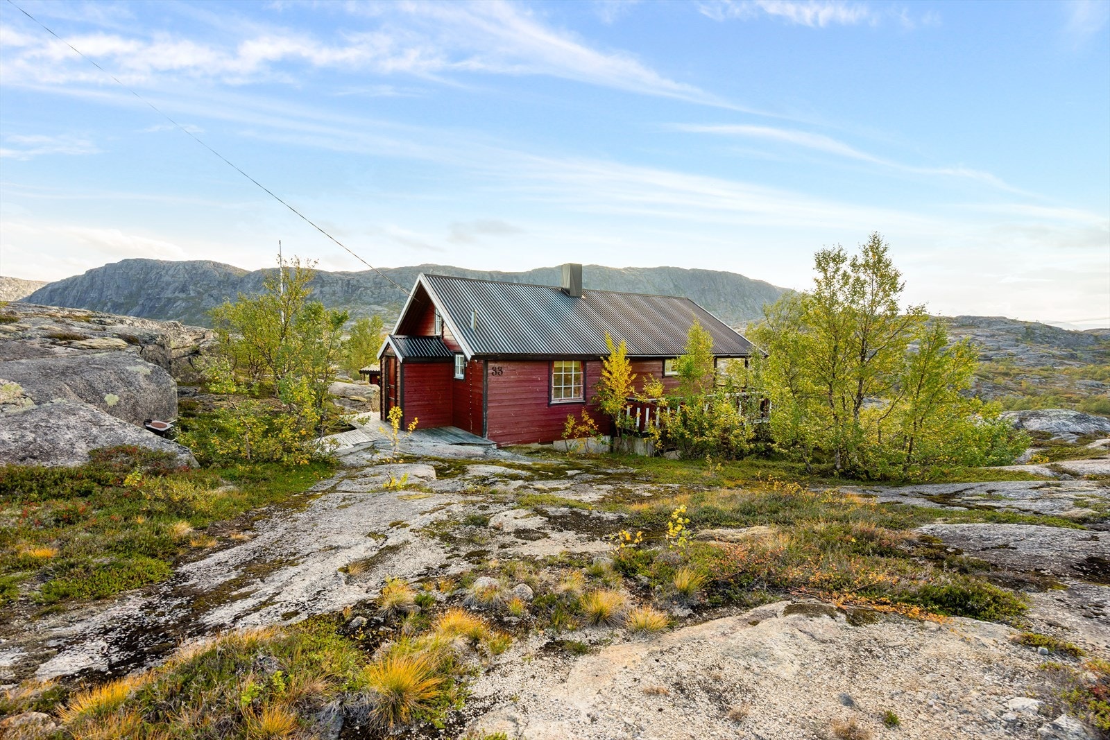 Hytta sett fra baksiden - omgitt av vakker natur og åpent landskap Galleribilde