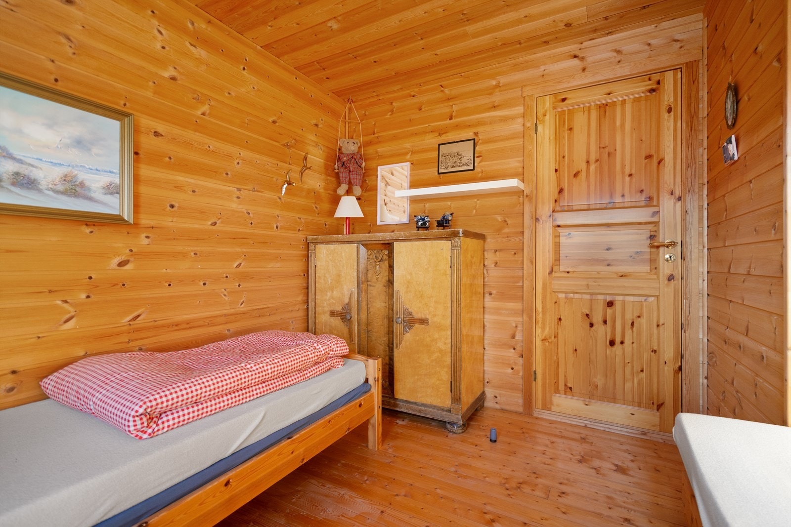 Hyggelig soverom med varm hyttefølelse og plass til både oppbevaring og senger Galleribilde