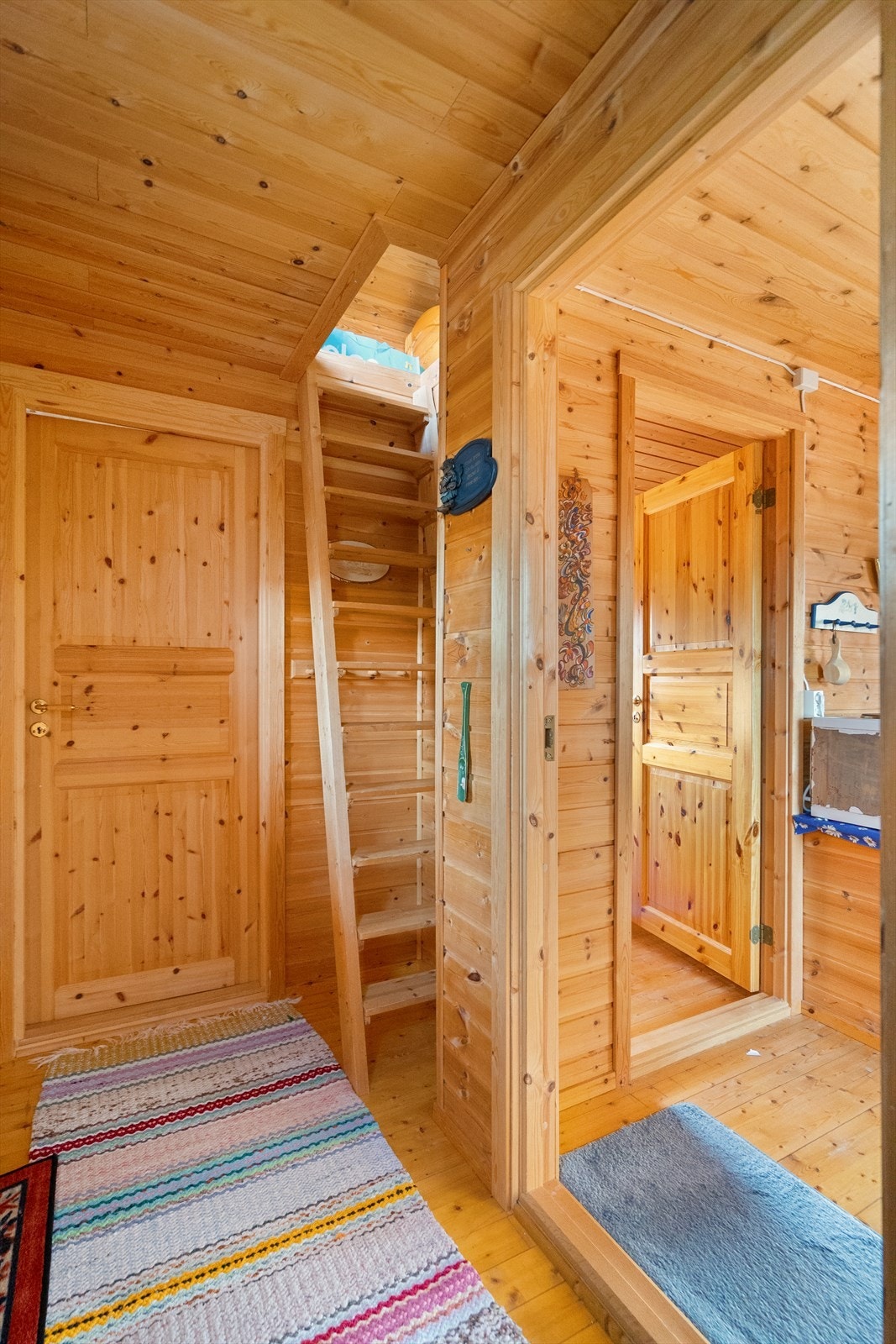 Koselig gang med treverk i alle flater og trapp opp til hems på loft - perfekt for ekstra soveplasser eller en liten hvilekrok Galleribilde