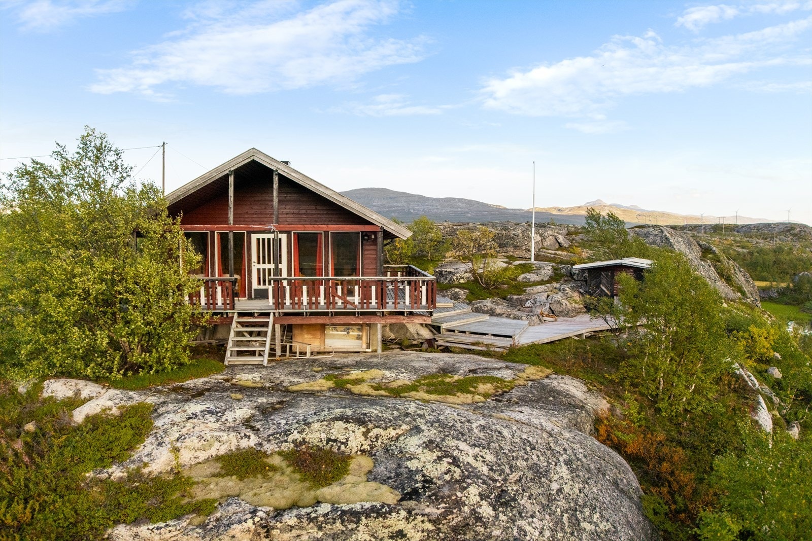 Sjarmerende hytte med klassisk rød fasade, idyllisk plassert på fjellknausen med flott utsikt Galleribilde