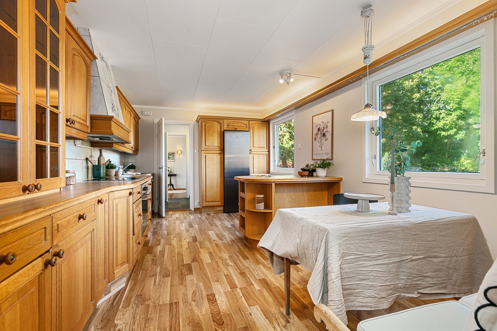 Kjøkken med hyggelig spiseplass og morgensol Galleribilde