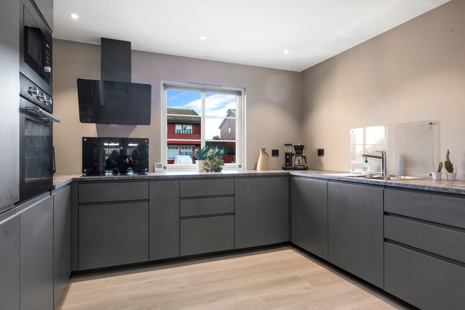 Kjøkken har innredning fra 2023 med slette grå fronter Galleribilde