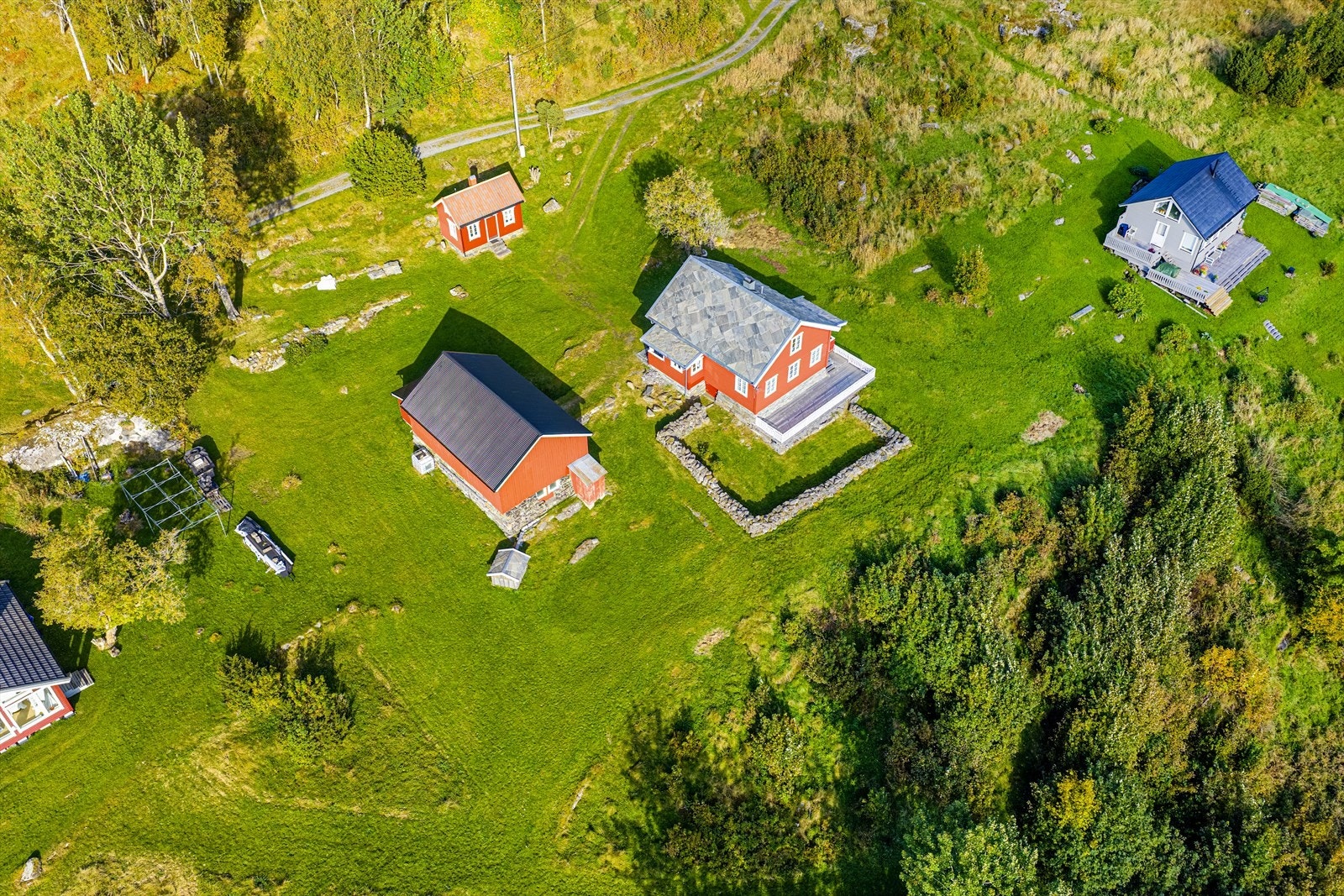 Eiendommen sett fra lufta | stor tomt på 2 287 m² er opparbeidet med treterrasse, skiferplatting, steingjerde og gressarealer Galleribilde