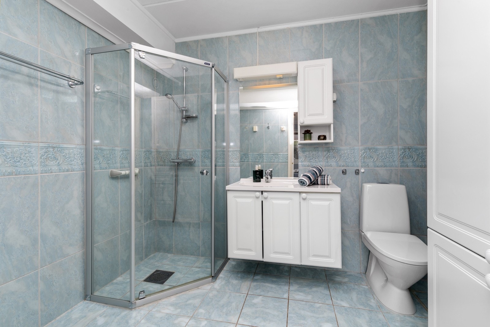 Flislagt bad med dusjhjørne, innredning og wc. Galleribilde