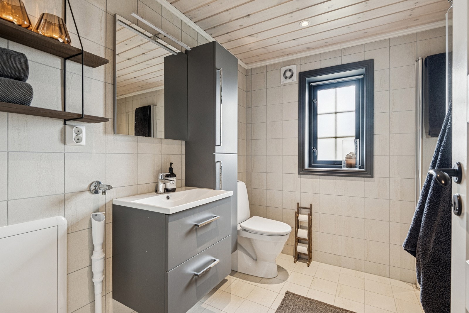 Hytta har et flott baderom med en smart dusjnisje med glassdører. Her er det god omkledningsplass og rom for vaskemaskin. Badet er flislagt og har varmekabler under flislagt gulv. Galleribilde