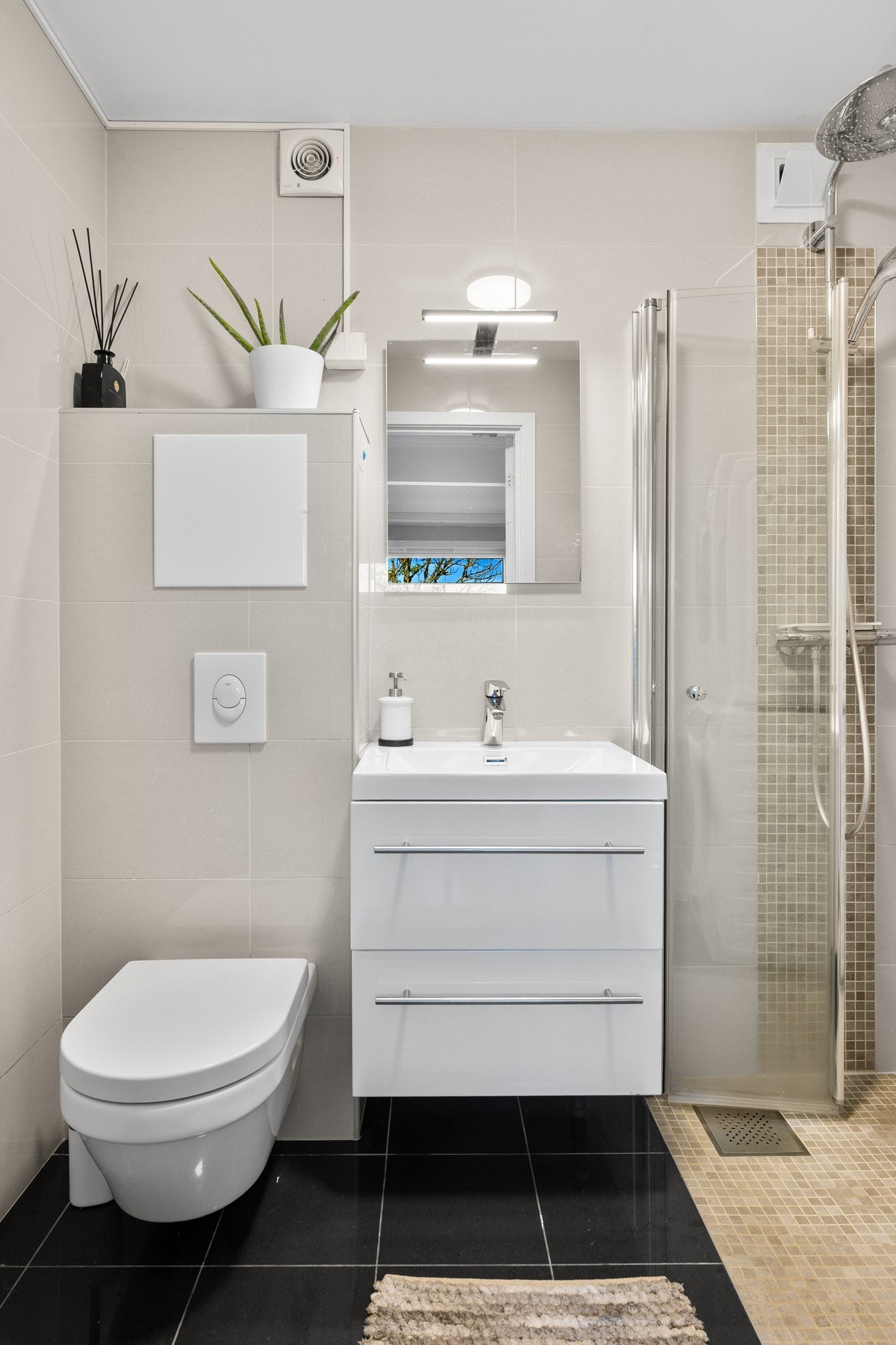 I boligens andre etasje ligger et kombinert bad og vaskerom med flislagte gulv og vegger, samt slett, hvitmalt tak. Galleribilde