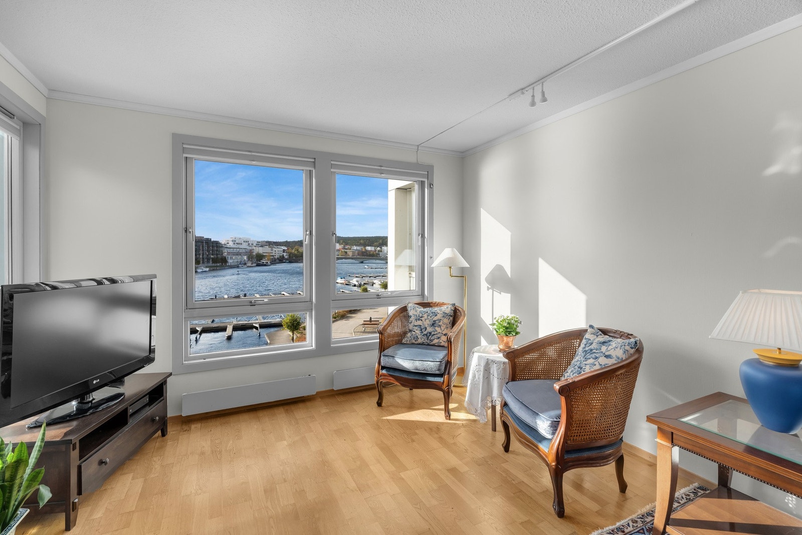 del av stue, hjørne med sol, lys og nydelig utsikt mot vannet Galleribilde