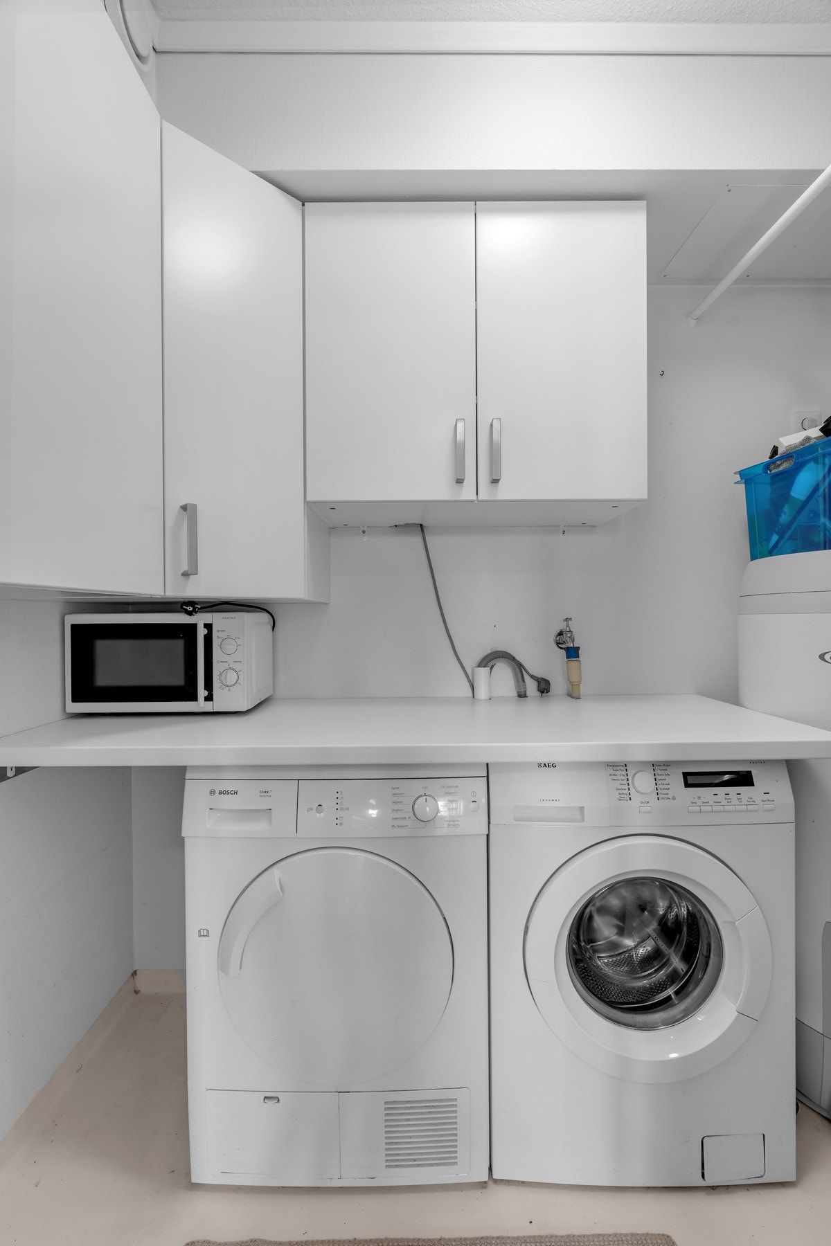 Praktisk vaskerom med plass til både vaskemaskin/tørketrommel og oppbevaring Galleribilde