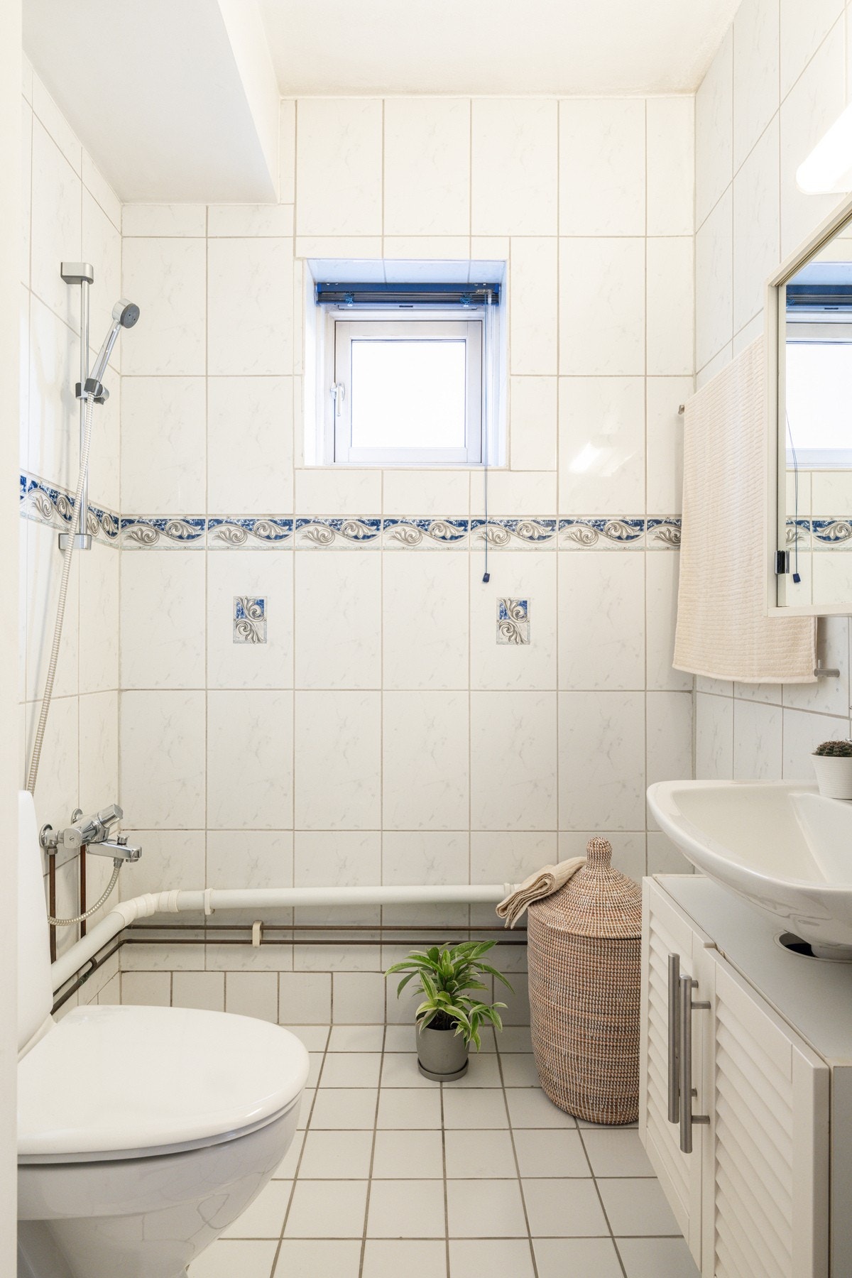 Praktisk og bad med flislagte gulv, dusjnisje og eget opplegg for vaskemaskin. Det er også felles vaskerom i borettslaget. Galleribilde