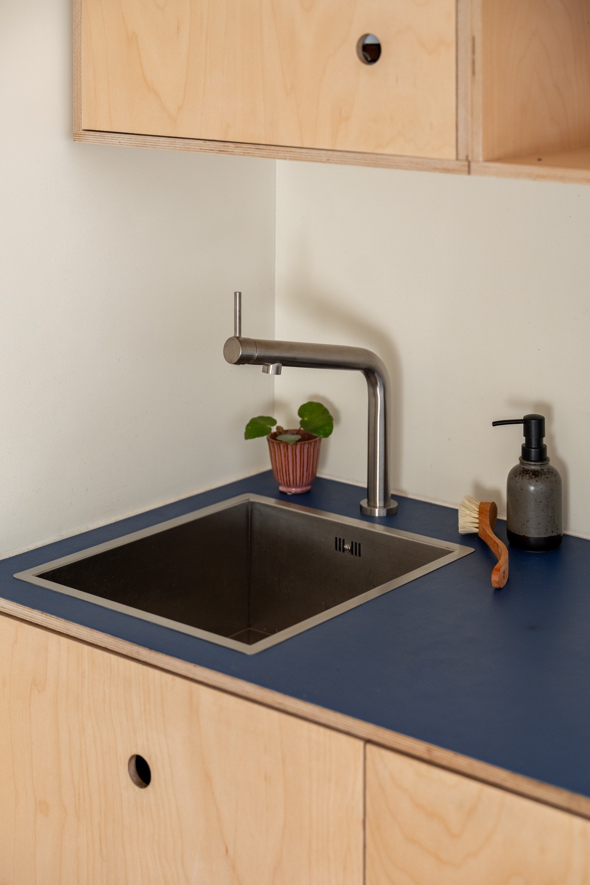 Finerfronter og en benkeplate i samme varme materiale gir kjøkkenet et nordisk preg med naturlig eleganse. Galleribilde