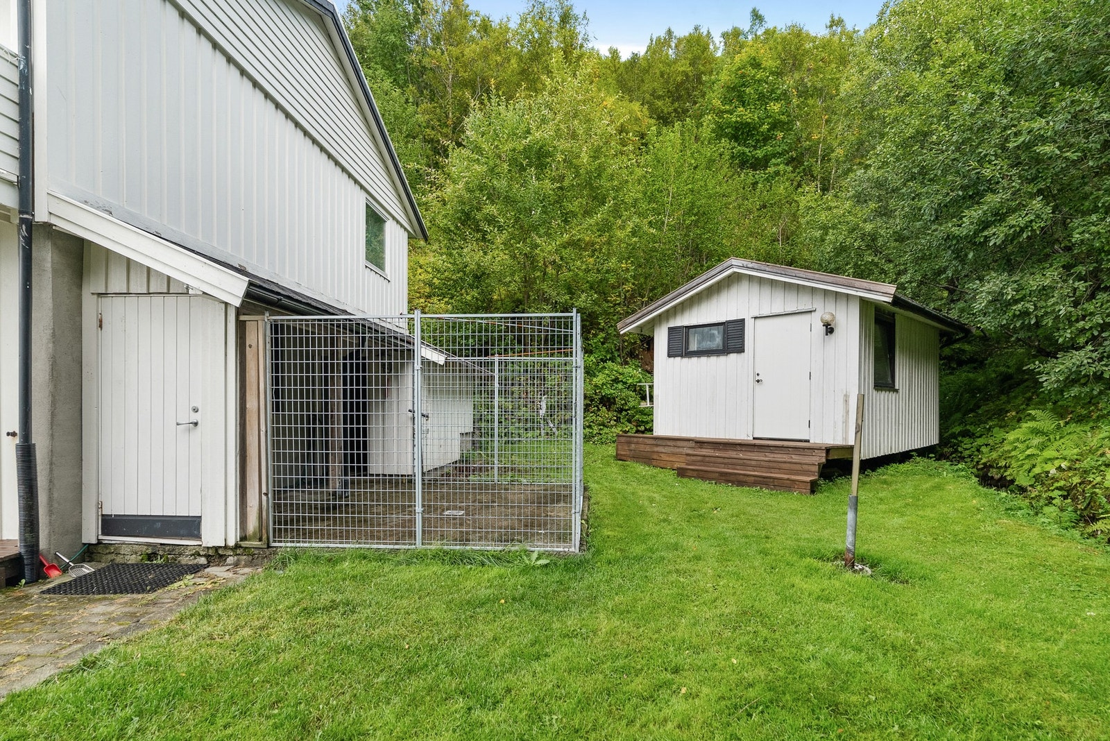 På østsiden har man overbygd areal med hundegård samt praktisk anneks. Her hører man bekken renne like ved Galleribilde