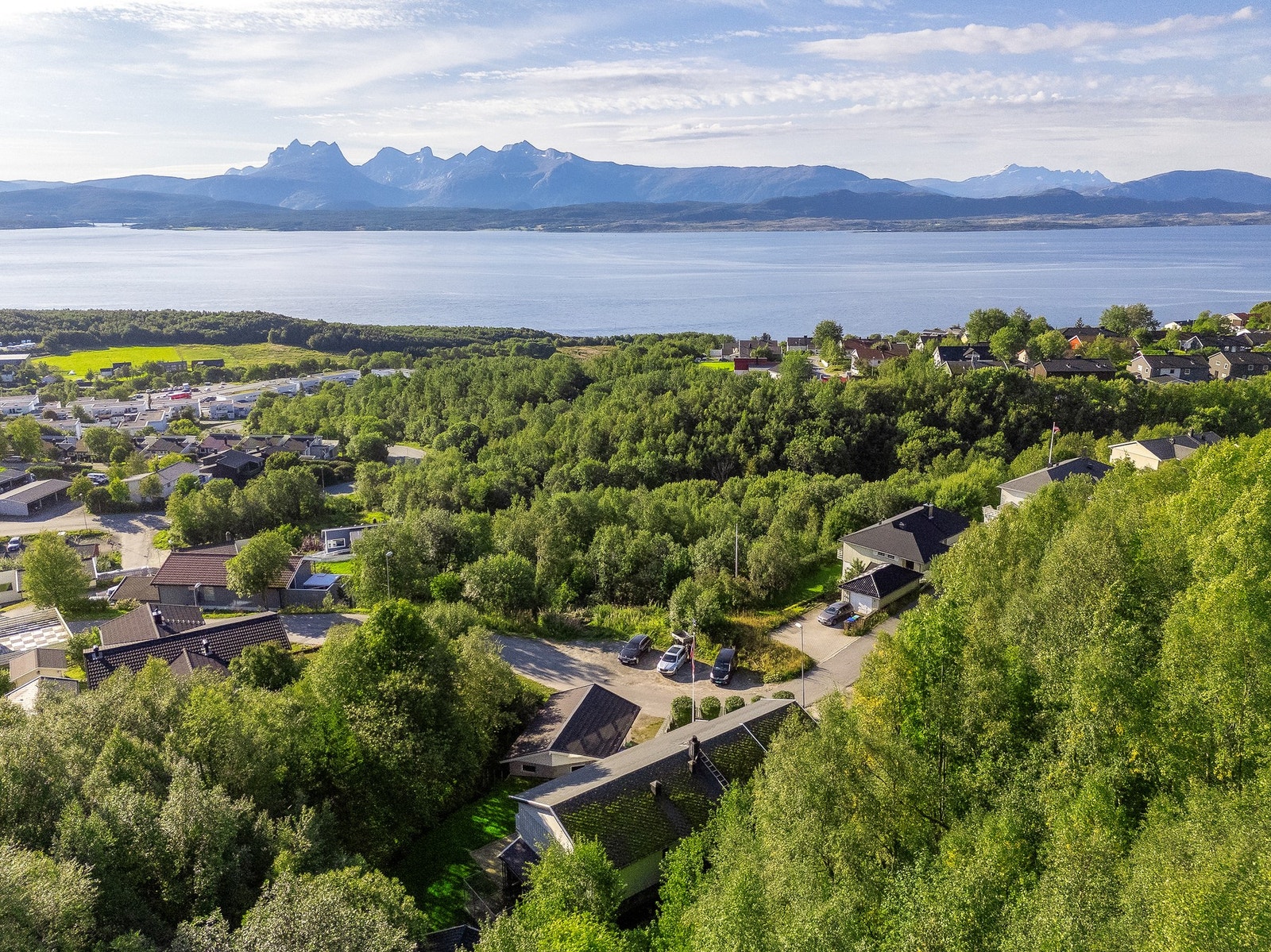 Utsikt mot grønne topper, hav og fjell fra balkongen og utearealene - taket er vasket etter bilde er tatt Galleribilde