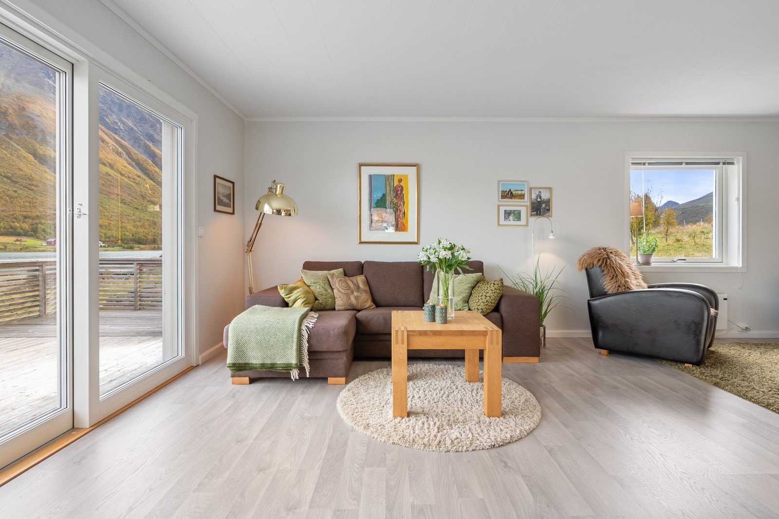 Lys og fin stue med vindusflater som slipper inn rikelig med naturlig lys og skaper en hyggelig atmosfære.