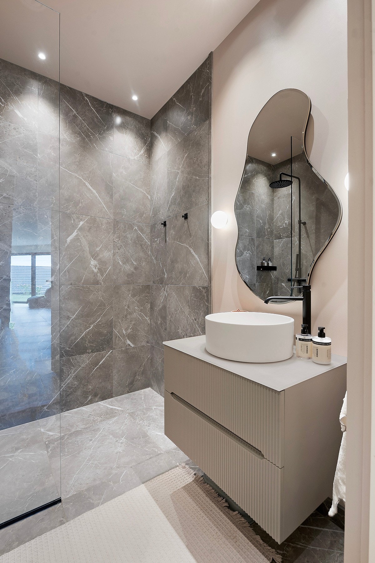 Elegant flislagt bad med dusjnisje og elegant servantinnredning med Tapwell armatur Galleribilde