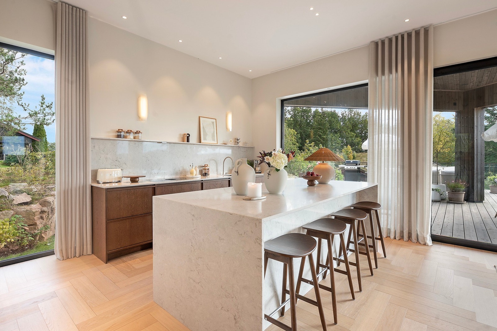 Romslig og åpent kjøkkenområde med ekstra lys i taket og store vindusflater mot både hage og terrasse Galleribilde