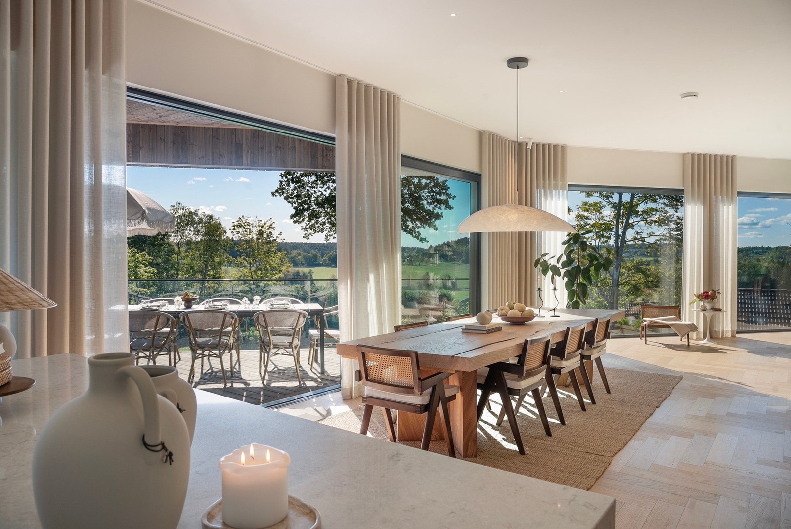 Lyst og åpent oppholdsrom som strekker seg ut til terrassen - Elegante materialvalg og fiksebenparkett på gulvet Galleribilde