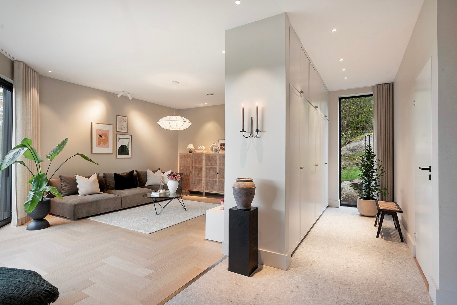 Smarte løsninger deler rommet, og skaper både praktisk garderobeplass og en innbydende TV-stue Galleribilde