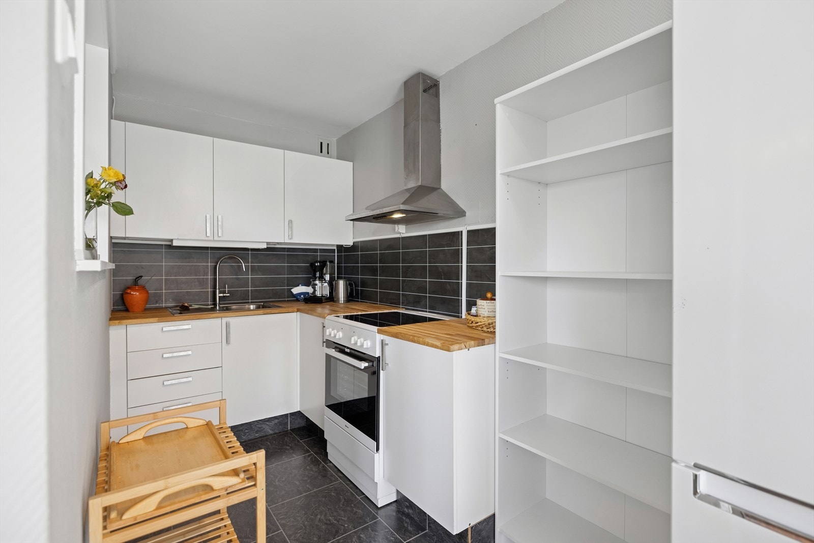 Kjøkkenet er fint plassert i tilknytning til stuen, og har godt med skap og benkeplass Galleribilde