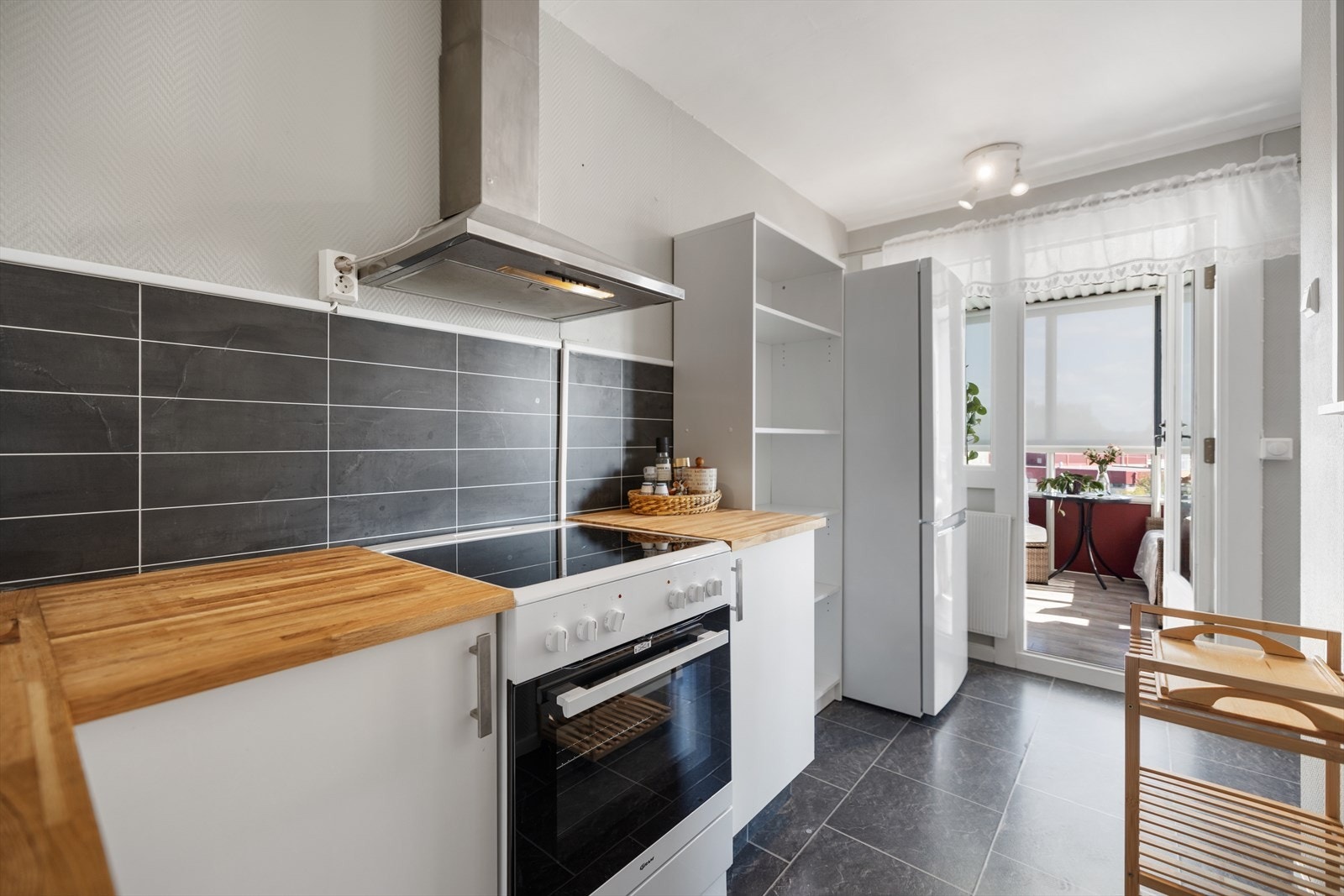 Fra kjøkkendelen er det utgang til en innglasset balkong med solskjerming Galleribilde