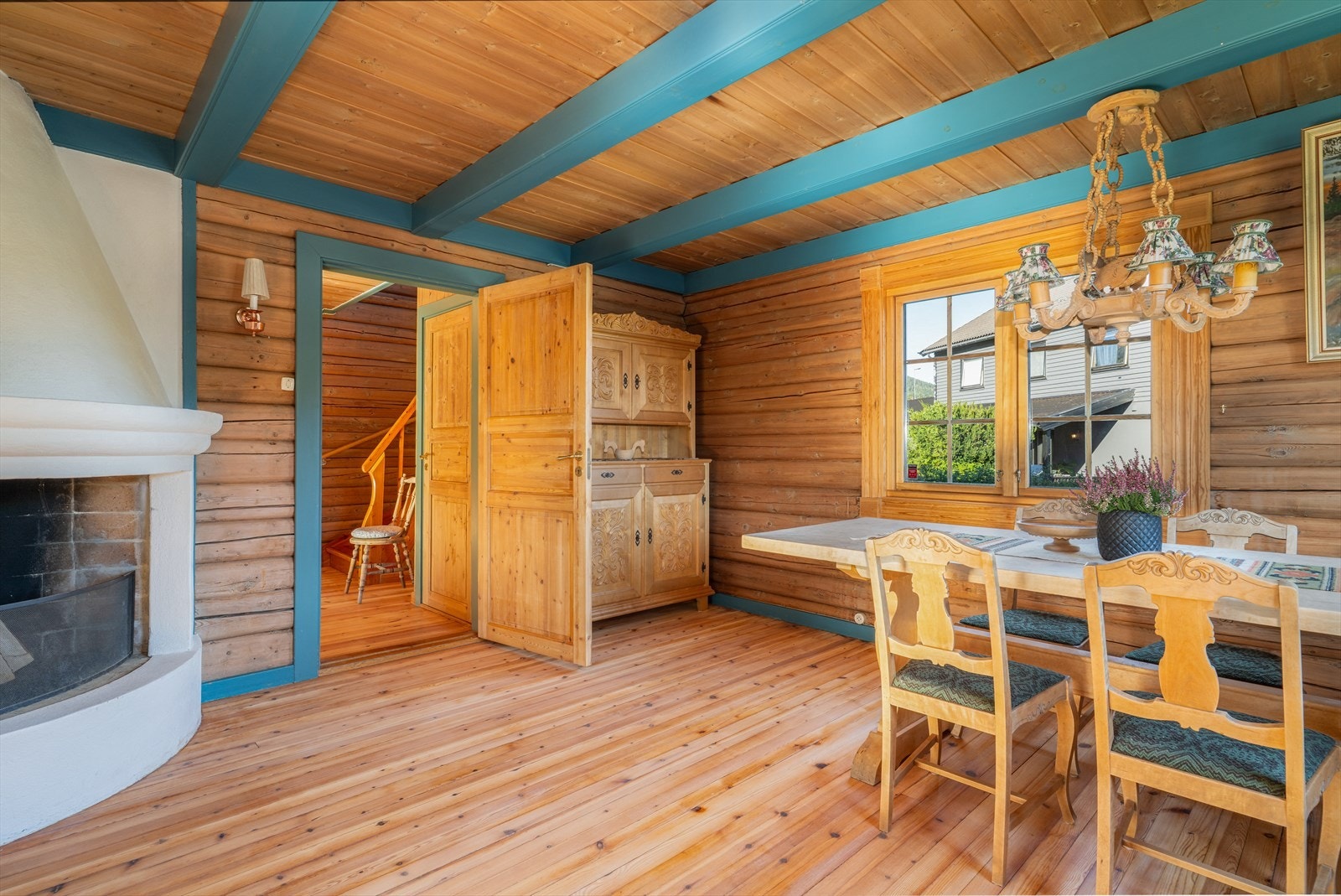 Hyggelig og innbydende spisestue med tømmervegger, furugulv og panel med bjelker i himling. Galleribilde