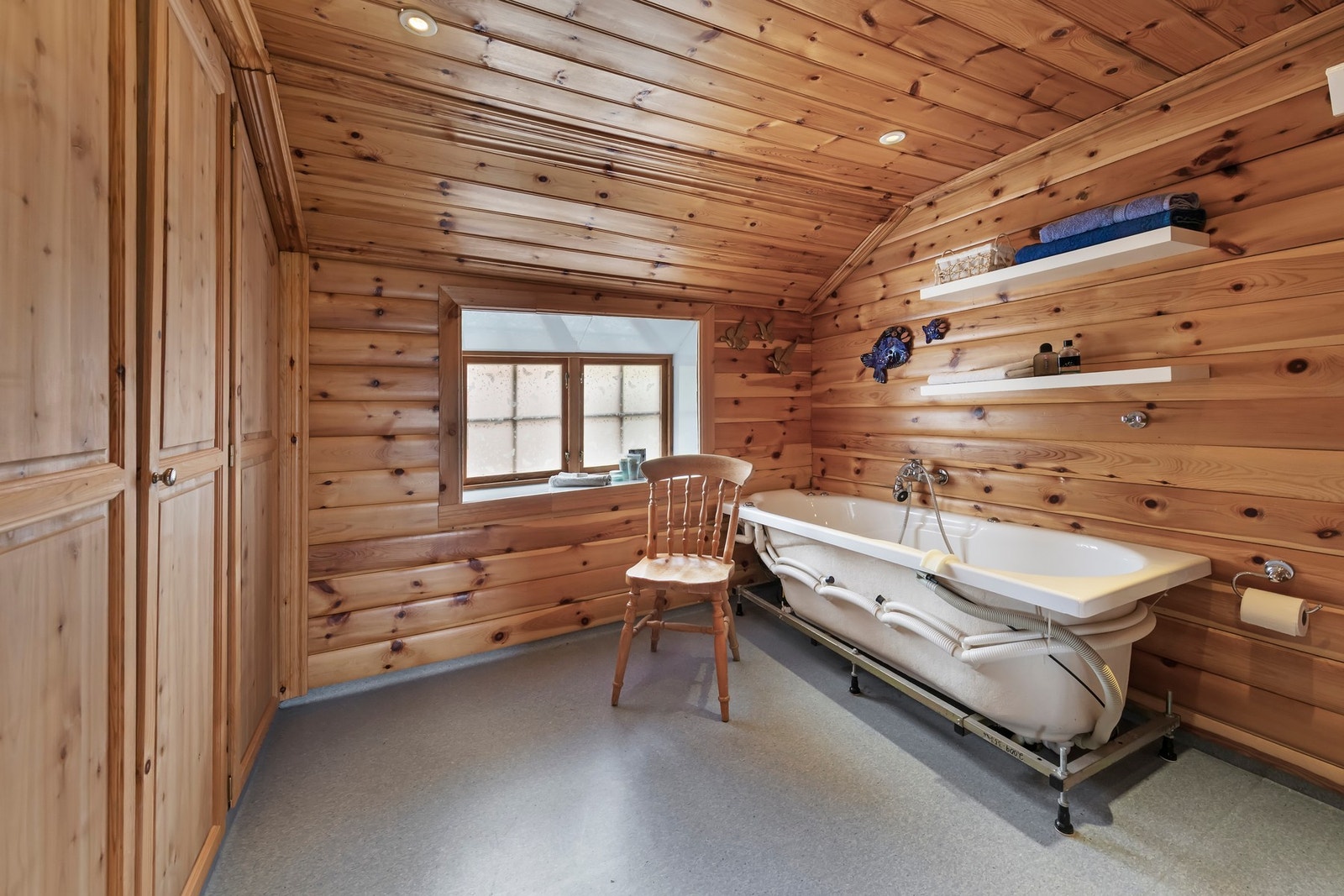 Bad hoveddel har badekar, servant og gulvmontert toalett. Plassbygde garderobeskap med heltrefronter Galleribilde