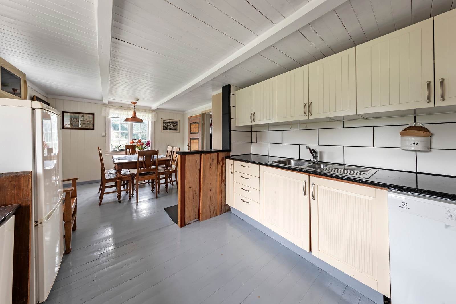 Kjøkken i kårleilighet har innredning med malte profilerte fronter/dører og benkeplate i laminat Galleribilde