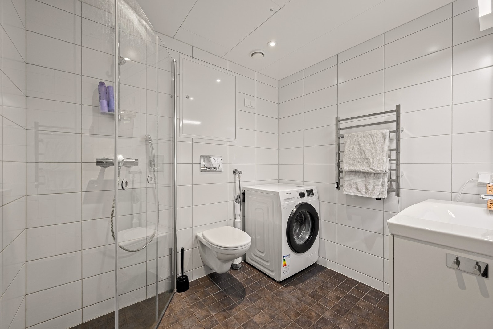 Romslig baderom med moderne uttrykk og gulvvarme Galleribilde