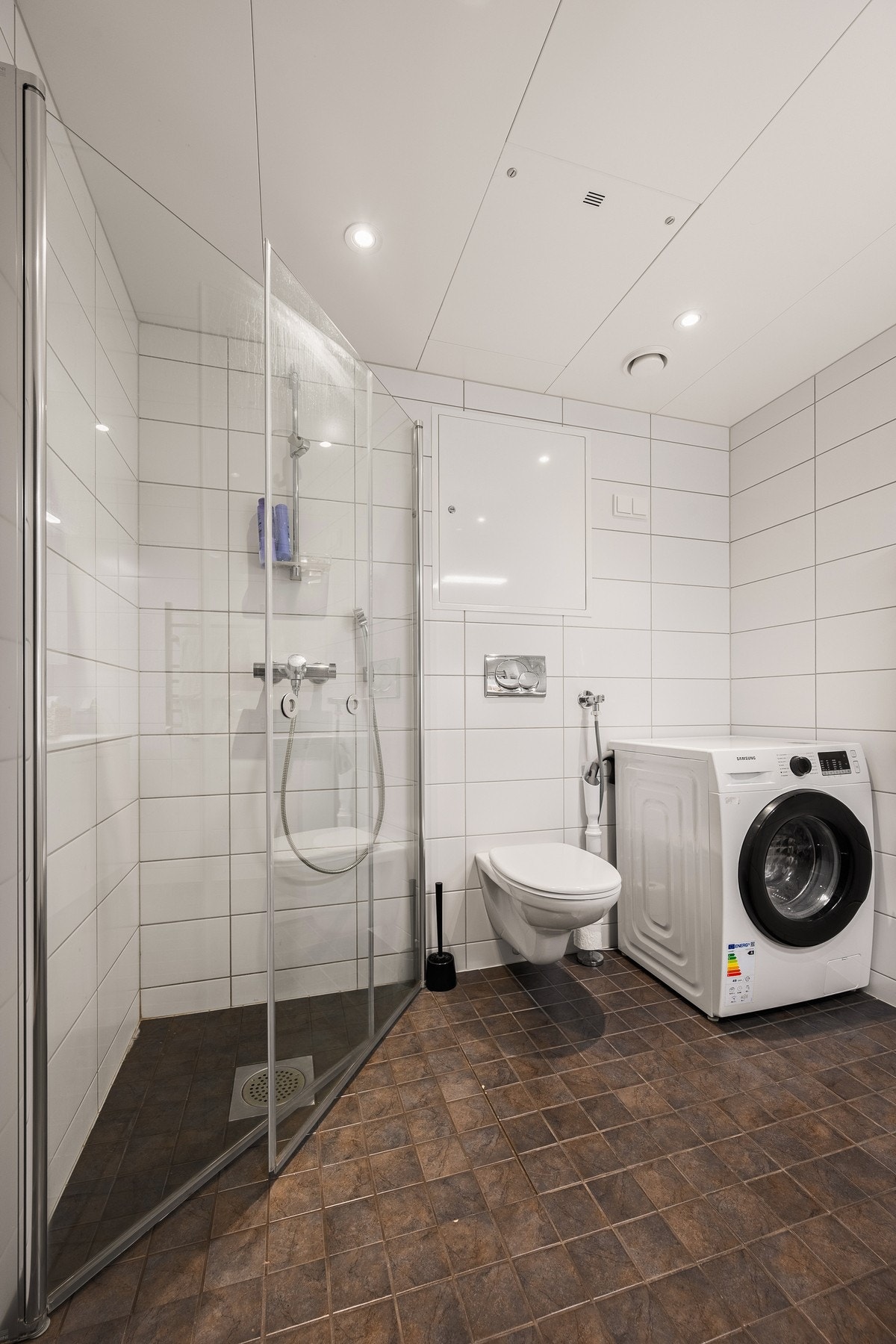 Bad med vegghengt toalett, dusj og plass til vaskemaskin/tørketrommel Galleribilde