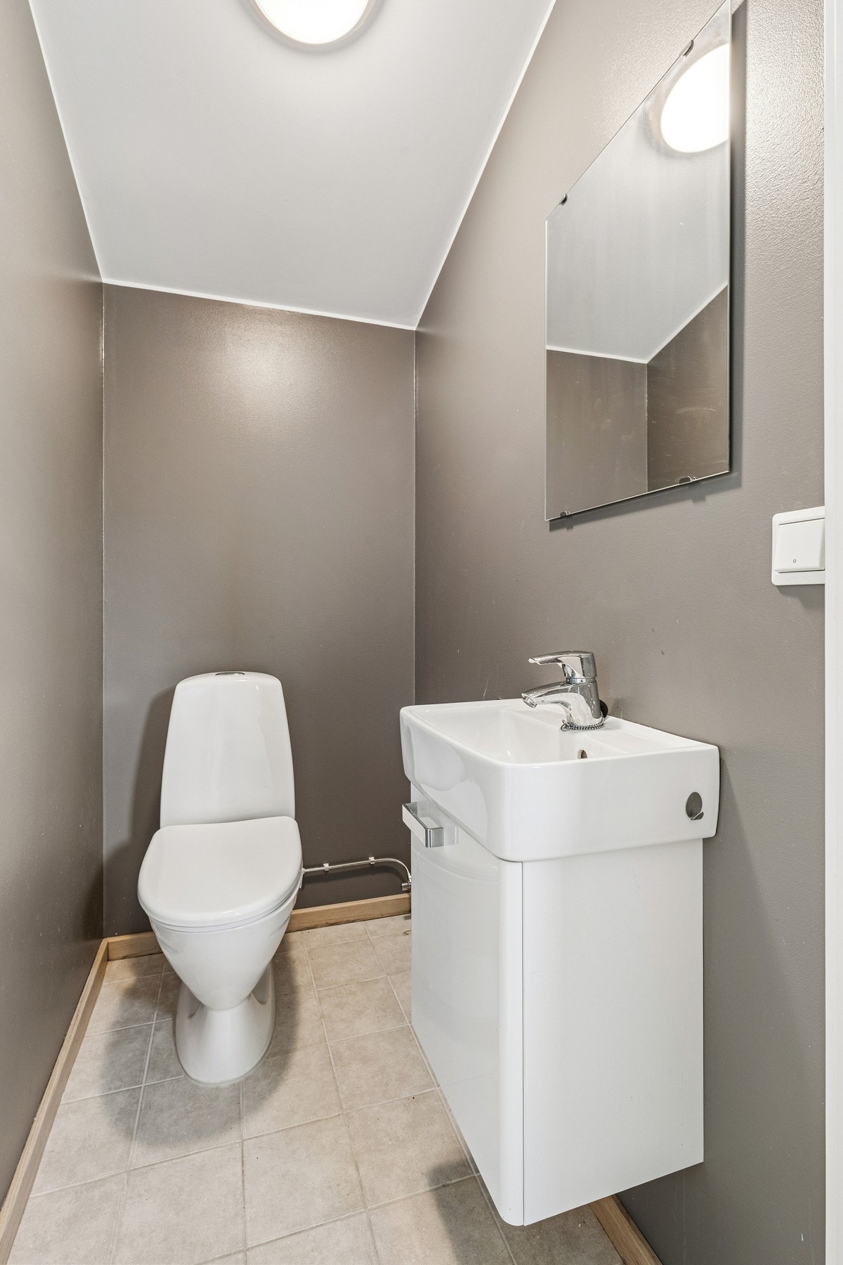 I gangen i andre etasje finner du et trivelig toalettrom med flislagt gulv, vegghengt servantinnredning og gulvstående toalett. Galleribilde