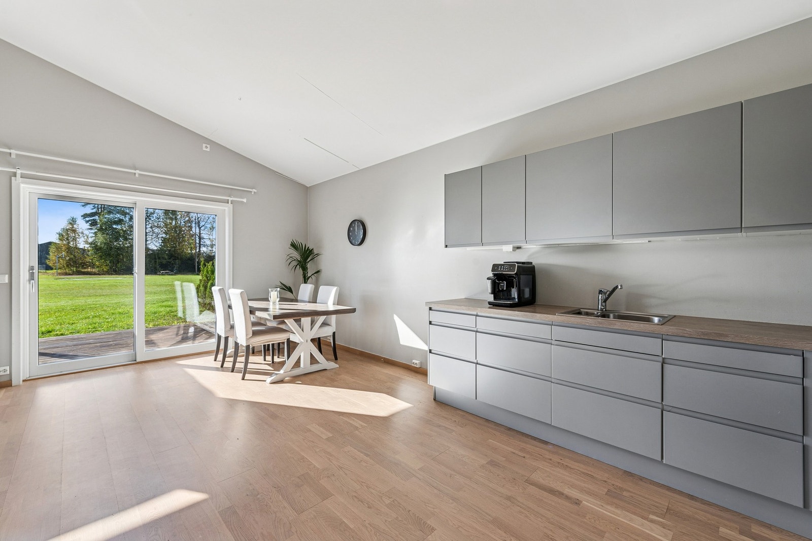 Moderne kjøkken med slette fronter og benkeplate av laminat samt delvis integrerte hvitevarer og induksjonstopp. Galleribilde