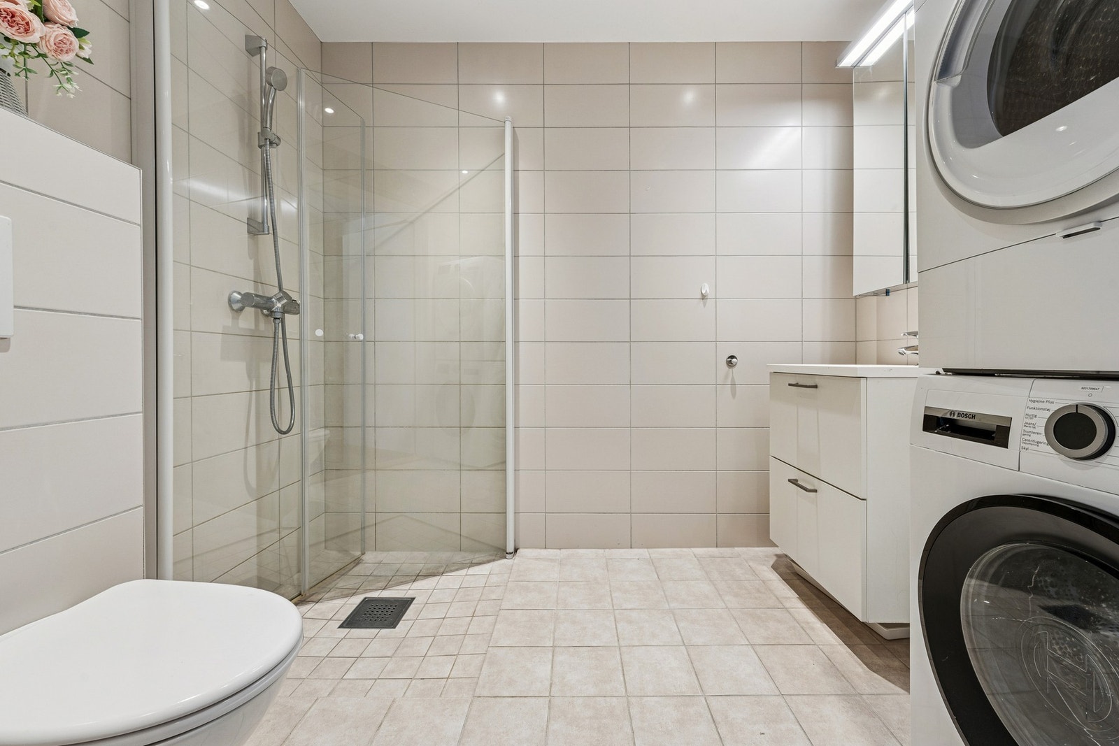 Lekkert og romslig bad med flislagte vegger og gulv med gulvvarme i tidløse farger. Galleribilde