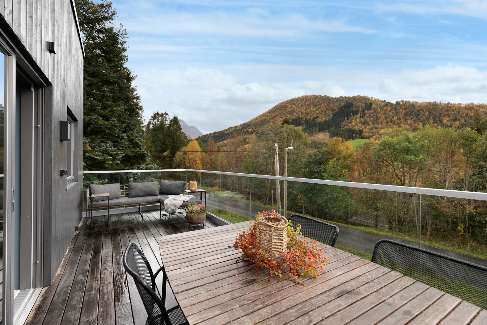 Balkongen har dekke av thermo ask terrassebord, glassrekkverk i front og strømuttak. Galleribilde