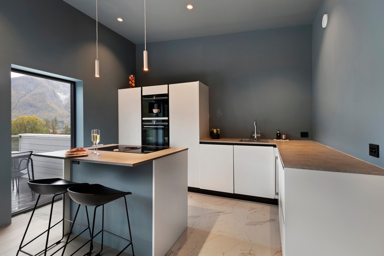 Fra stue er det åpen løsning mot kjøkkenet. Påkostet kjøkkeninnredning fra Kvik i hvite, slette fronter. Galleribilde