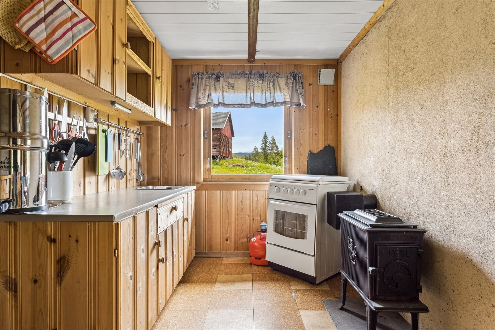 Kjøkken med komfyr og vedovn. Galleribilde