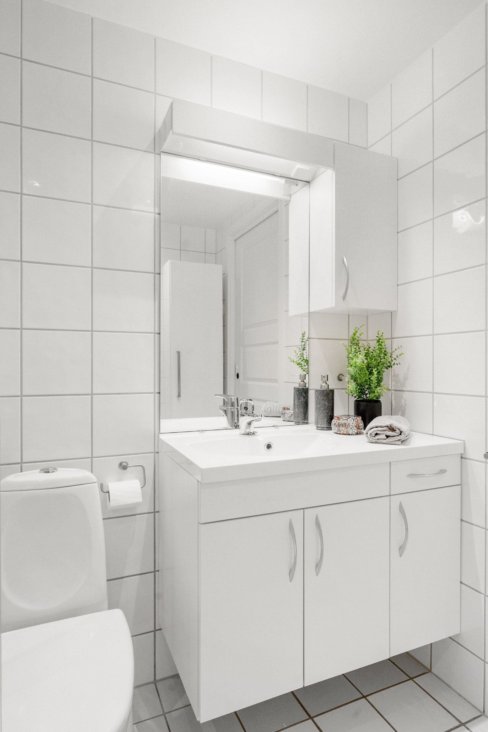 Hvit baderomsinnredning godt med skapplass. Galleribilde